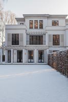Extérieur de maison classique avec jardin couvert de neige en hiver