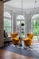 Paire de chaises orange dans le salon avec un sol monochrome