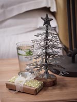 Sapin de Noël miniature et cadeau sur table de chevet