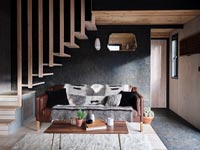 Salon moderne avec escalier en bois au-dessus d'un coin salon