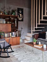 Espace de vie moderne décloisonné avec mobilier vintage et escalier