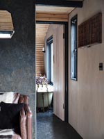 Vue dans la salle de bains moderne par des portes en bois internes ouvertes