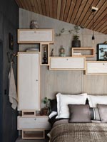 Chambre moderne avec réseau de placards de rangement en bois fixés au mur