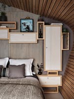 Chambre moderne avec réseau de placards de rangement en bois fixés au mur