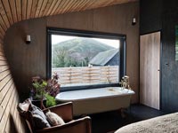 Baignoire à côté de la fenêtre dans la chambre en bois moderne