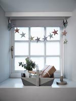 Trug en bois peint en gris et étoile bunting sur le rebord de la fenêtre