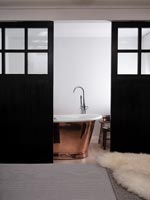 Baignoire autoportante en cuivre dans la salle de bains moderne