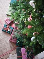 Cadeaux emballés rose et bleu sous l'arbre de Noël