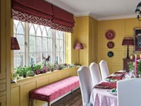 Siège rose à côté de la fenêtre dans la salle à manger classique décorée pour Noël