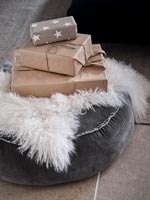 Cadeaux de Noël emballés sur pouf gris
