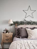 Guirlande et étoile au-dessus de la tête de lit dans la chambre moderne