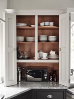 Unité de cuisine moderne - portes de placard ouvertes révélant le rangement de la vaisselle
