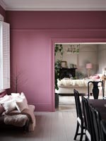 Murs peints en rose dans la salle à manger moderne avec petit canapé