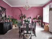Salle à manger moderne avec murs peints en rose et sol blanc