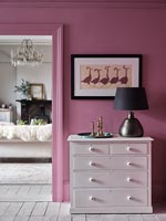 Commode blanche contre mur peint en rose