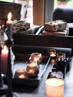 Détail de cadeaux emballés et bougies sur table basse