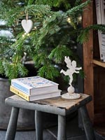 Livres et ornement d'ange à côté de l'arbre de Noël