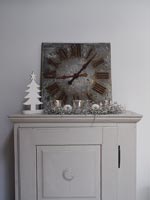 Horloge sur petite armoire avec décorations de Noël