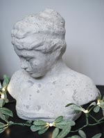 Buste en pierre d'une jeune femme décorée de guirlandes lumineuses