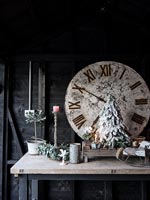 Grande horloge, décorations de Noël et bougies sur table en bois