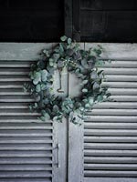 Petite couronne de Noël verte sur les portes à lattes de bois peintes en gris
