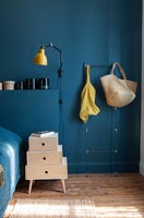 Murs peints en bleu foncé et armoire de chevet dans une chambre moderne