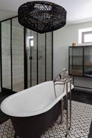 Salle de bains monochrome moderne avec baignoire sur pieds au centre