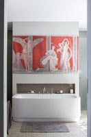 Oeuvre colorée au-dessus de la baignoire dans la salle de bains moderne