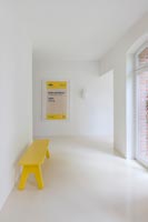 Couloir contemporain peint en blanc avec des illustrations jaunes et un banc