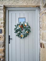 Guirlande de Noël sur la porte d'entrée de la maison de campagne