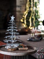 Petit arbre de Noël argenté sur table d'appoint