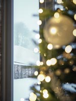 Vue sur la campagne couverte de neige à travers la fenêtre à côté de l'arbre de Noël