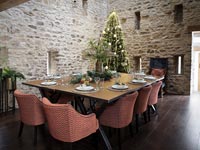 Salle à manger champêtre avec murs en pierres apparentes décorées pour Noël