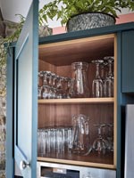 Ouvrez la porte de l'armoire de cuisine avec des étagères de verres
