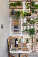 Affichage des plantes d'intérieur sur un mur couvert de palettes