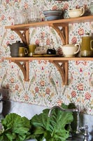 Papier peint à motifs et étagères en bois dans la cuisine