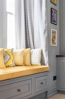 Siège de fenêtre encastré en bois gris avec coussins jaunes