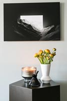 Fleurs sur table d'appoint avec photo en noir et blanc ci-dessus