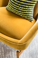 Détail de la chaise rembourrée de couleur moutarde