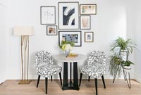 Table et chaises modernes avec affichage d'œuvres d'art encadrées sur le mur