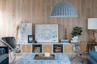 Salon avec murs en planches de bois et décoration sur le thème bleu