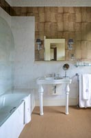 Salle de bain de style champêtre avec lavabo sur colonne et sol naturel