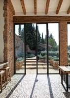 Salle à manger moderne avec sol en galets texturés avec vue sur le jardin