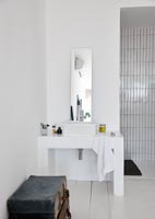Zone de douche carrelée blanche et lavabo moderne
