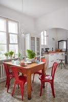 Chaises rouges autour d'une petite table en bois dans la cuisine-salle à manger