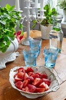 Bol de fraises et verres d'eau sur table en bois