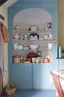 Armoire peinte en bleu avec étagères dans la cuisine-salle à manger de campagne