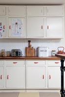 Armoires de cuisine blanches avec poignées rouges dans la cuisine moderne