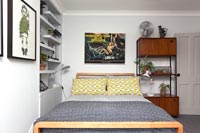 Literie jaune et grise et mobilier vintage dans une chambre moderne
