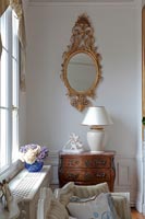 Miroir doré et meubles anciens dans un salon classique